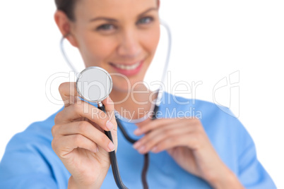 Smiling surgeon holding up stethoscope