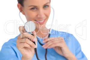 Smiling surgeon holding up stethoscope