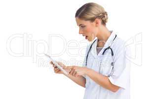 Side view of surprised nurse with tablet pc