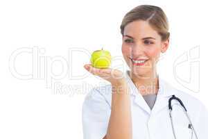 Nurse looking at the apple placed on her hand