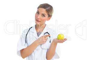 Nurse pointing to green apple on her hand