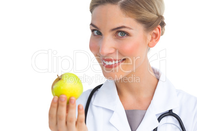 Pretty nurse showing apple to the camera