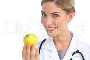 Pretty nurse showing apple to the camera