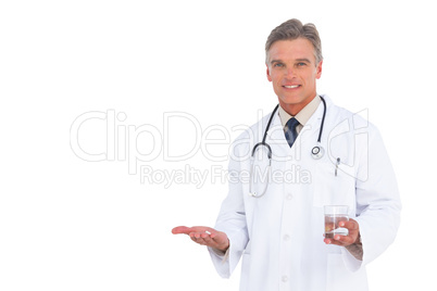 Smiling doctor holding medicine and water glass