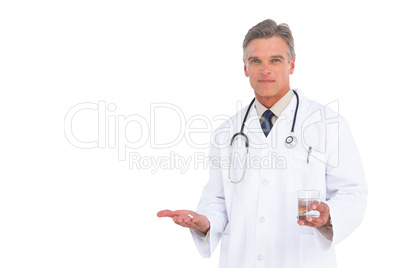 Serious doctor holding drugs and water glass