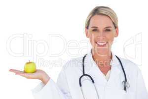 Smiling doctor holding apple