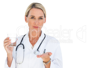 Happy doctor with medication and a glass of water in her hands