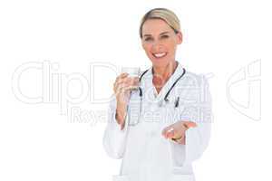 Happy doctor with pills and a glass of water in her hands