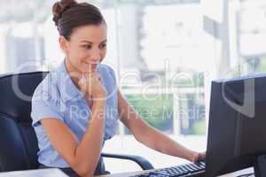 Businesswoman working on her computer and smiling