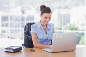 Happy businesswoman working on her laptop