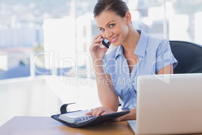 Smiling businesswoman calling with her mobile phone