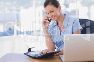 Smiling businesswoman calling with her mobile phone
