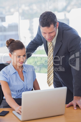 Business people working together on a laptop and smiling