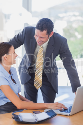 Smiling business people working together with a laptop Smiling business people working together with a laptop