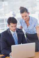 Business people smiling and working together with a laptop