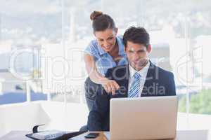 Businesswoman pointing to the laptop and smiling