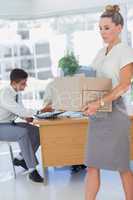 Businesswoman holding a box and his colleagues in the bottom
