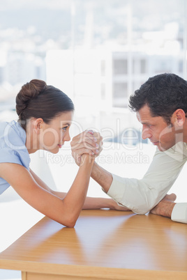 Competitive business people arm wrestling