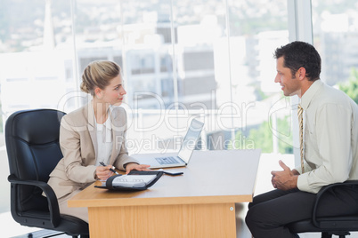 Smiling businesswoman interviewing businessman