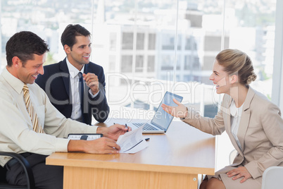 Business people laughing with interviewee