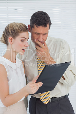 Business people looking at clipboard