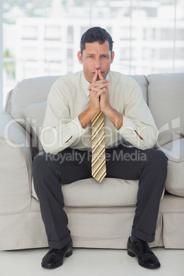 Businessman thinking with hands together