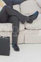 Businessman with legs crossed on couch