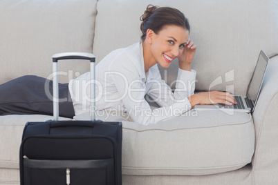Business woman lying on couch and looking at camera
