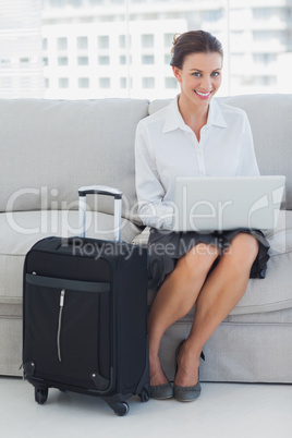 Businesswoman sitting on the couch with laptop