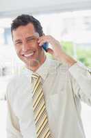 Businessman on the phone smiling at camera
