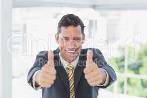 Smiling businessman with thumbs up