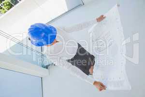 Overhead of an architect holding a blueprint