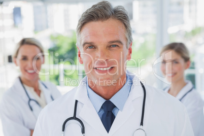 Charismatic doctor standing with colleagues