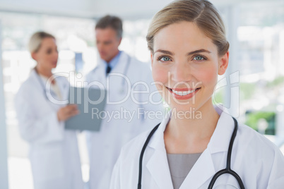 Smiling blonde haired doctor standing in her office