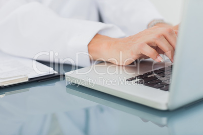 Doctor hands typing on a laptop
