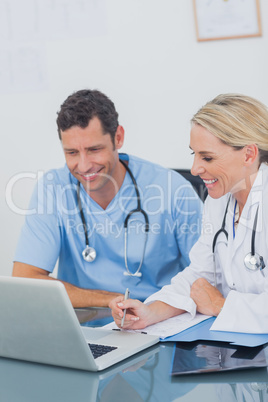 Two doctors working together on a laptop