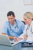 Two doctors working together on a laptop