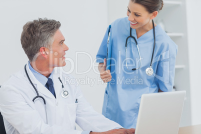 Doctor with a clipboard talking to a colleague