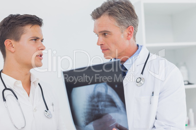Two doctors holding and analysing an xray