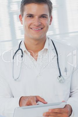 Smiling doctor using tablet