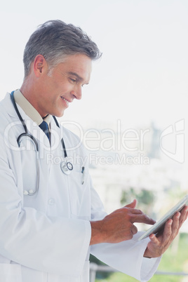 Grey haired doctor using digital tablet