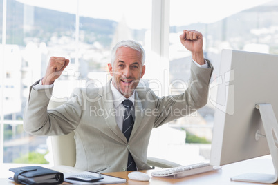 Businessman cheering in his office