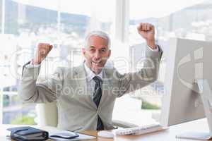Businessman cheering in his office