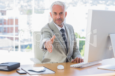 Smiling businessman reaching out hand for handshake