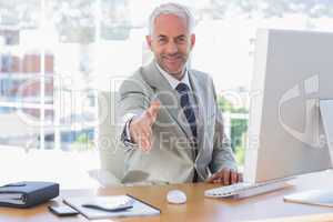 Smiling businessman reaching out arm for handshake