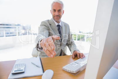 Happy businessman reaching arm out for handshake