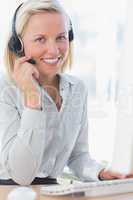 Businesswoman using headset and smiling at camera