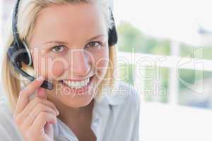 Businesswoman with headset smiling at camera