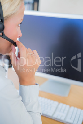 Businesswoman with headset looking at computer