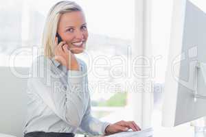 Young businesswoman on the phone smiling at camera